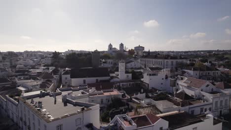 Church-of-Santa-Maria-do-Castelo-a-National-monument-from-Tavira-Downtown,-Aerial-Orbiting