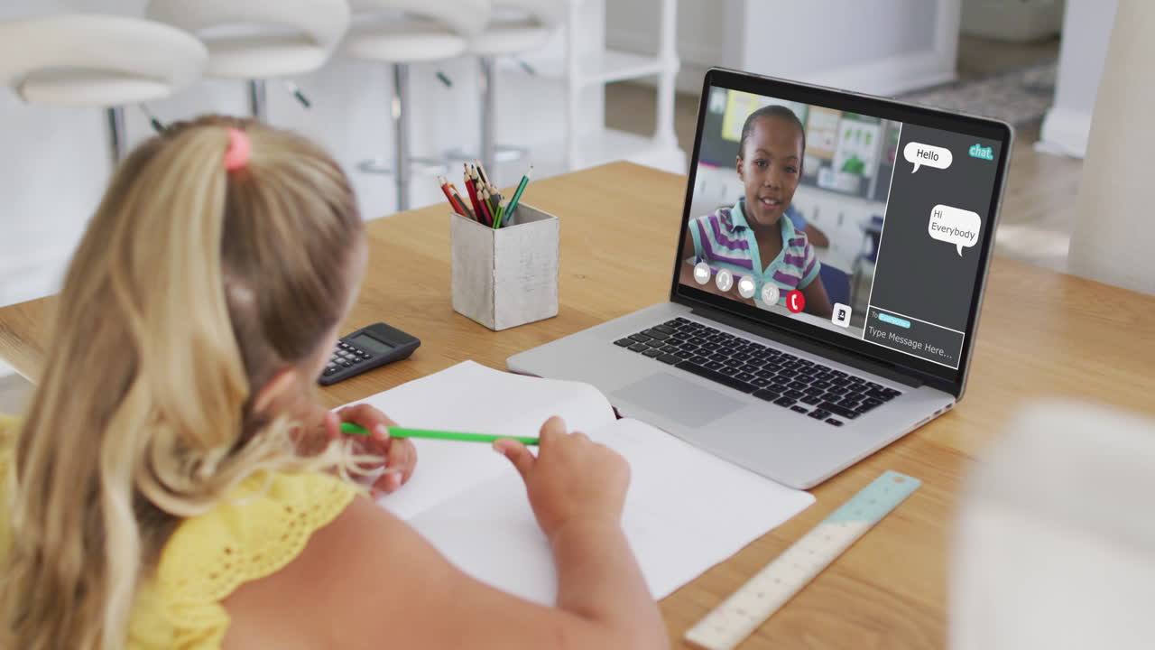 Schulmädchen nutzt Laptop für Online-Unterricht zu Hause, mit ihrer Mitschülerin und Web-Chat auf dem Bildschirm.