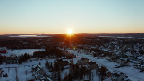 Picturesque-sunset-aerial-view-of-snow-covered-homes-in-a-suburban-subdivision