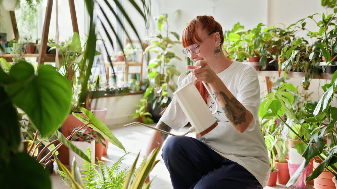 식물 가게 에서 식물 에 물 을 주고 있는 여자
