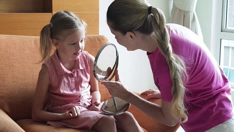 madre ayudando a su hija con el maquillaje