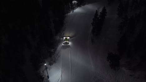 snow machine at work in idre, sweden during a late evening in the dark