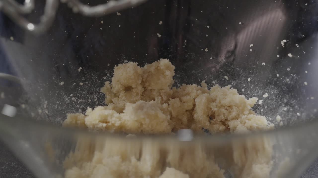Tilføjelse af vaniljeekstrakt til cookiedej i glasskål. Nærbillede.