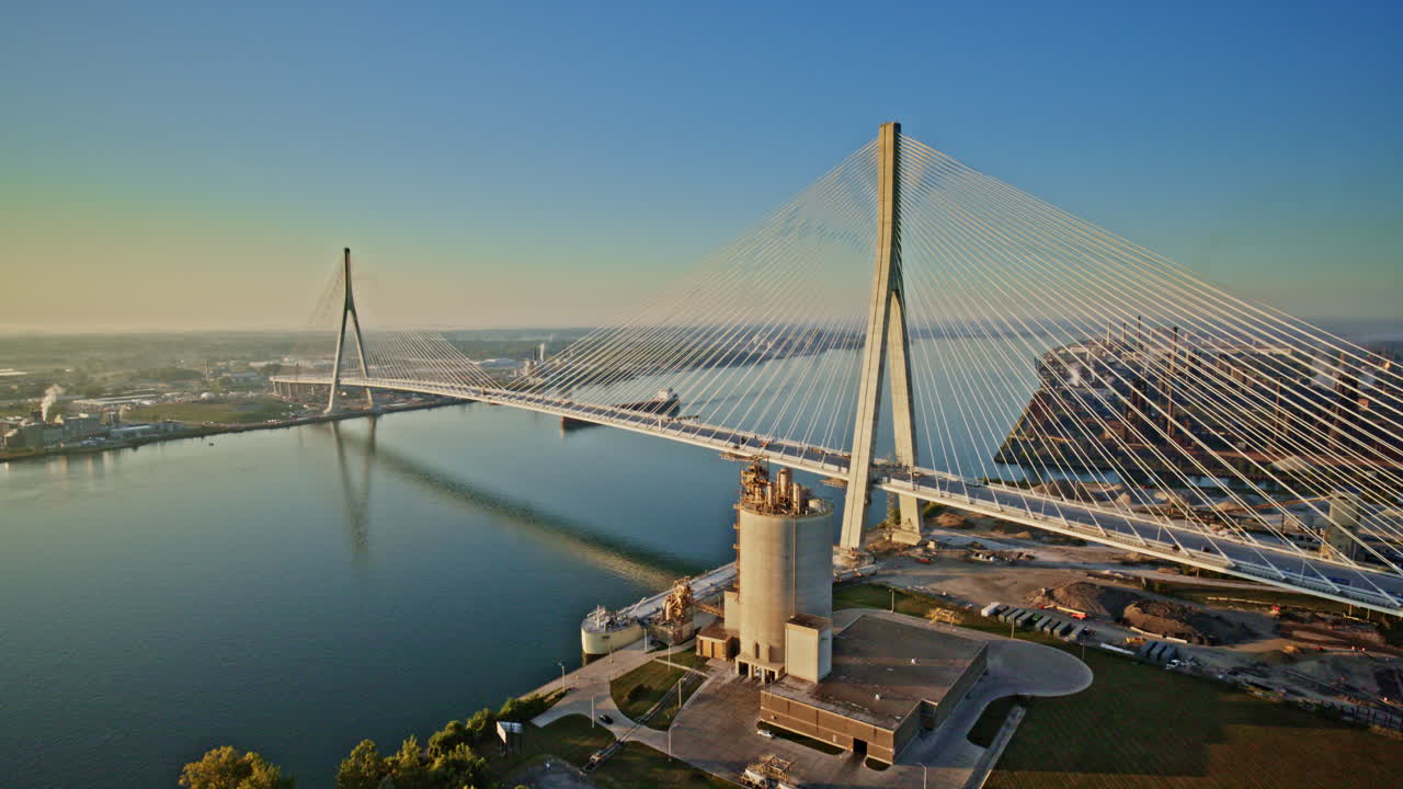 Aerial drone flyover of a freighter moving beneath the massive Gordie Howe International Bridge