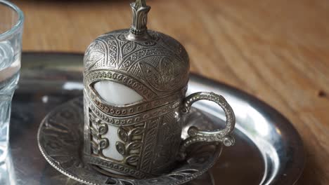 close-up of an ornate turkish coffee cup and glass of water