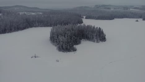 aerial view of a frozen lake and snow covered island in the winter