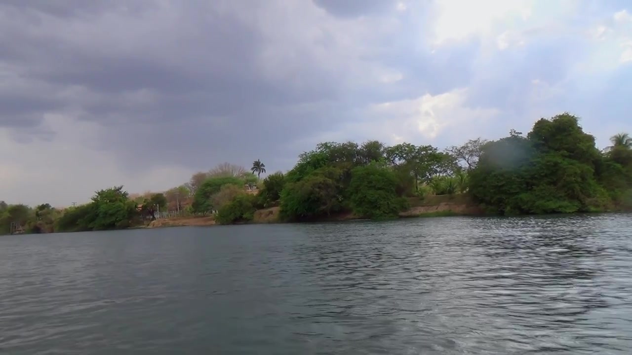 Vista lungo il fiume con nuvole cariche di pioggia