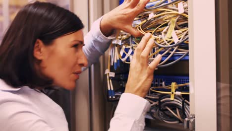 technician checking cables in a rack mounted server