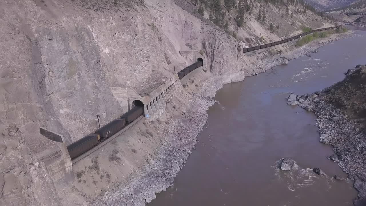 tren de vagones de tolva abierta transportar mineral a través de túneles del cañón del río