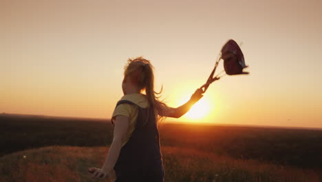 Ein-Sorgloses-Kind-Mit-Einem-Rucksack-Hinter-Sich-Läuft-Der-Sonne-Entgegen-Sommerferien-Und-Freiheitskonzept