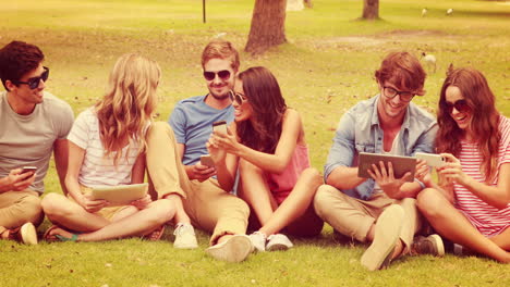 Happy-friends-in-the-park-using-electronic-devices