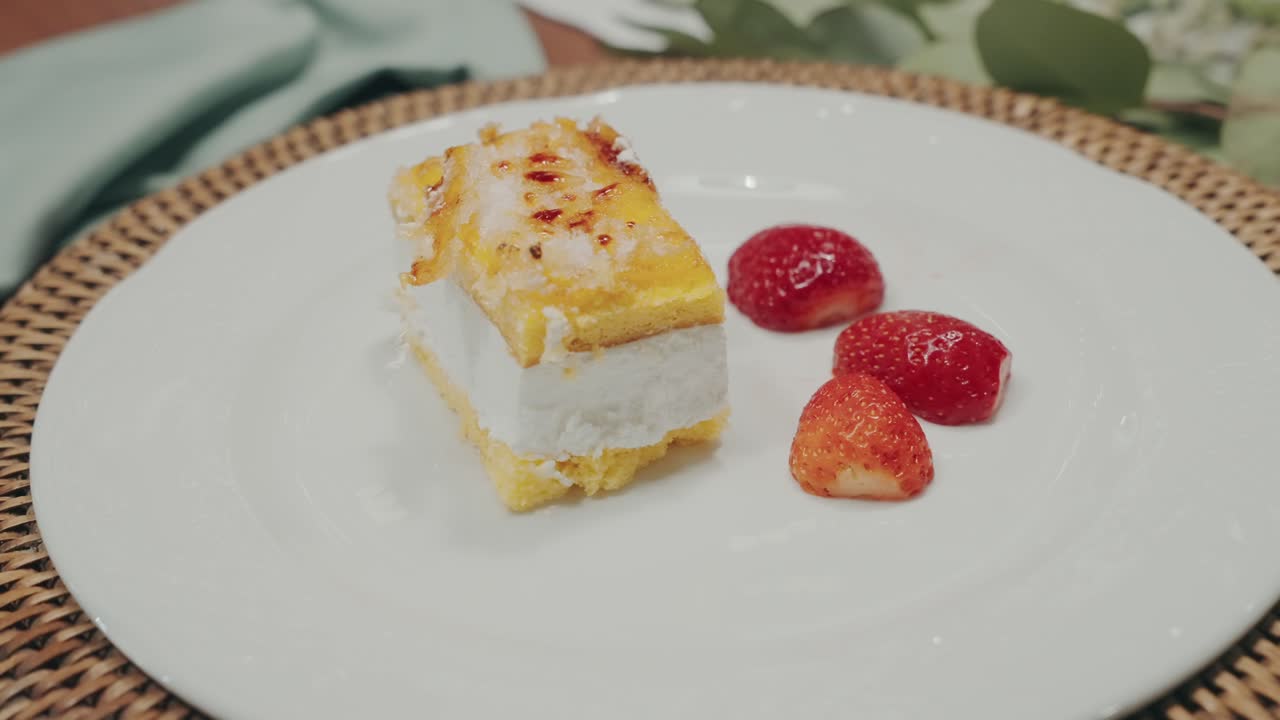 흰 접시에 신선한 딸기가 올려진 레이어 케이크 조각