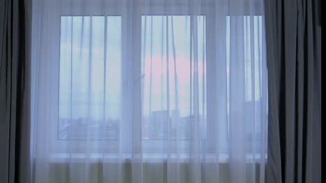 lapso de tiempo del cielo nublado de la noche fuera de la ventana con cortinas