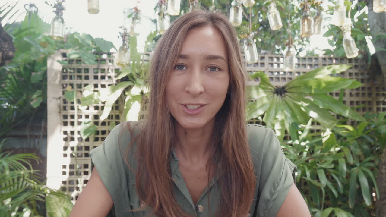 Woman Talking on Camera on Tropical Terrace