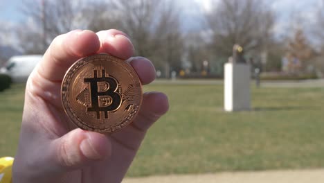 Kupfer-Bitcoin-Token-Mit-Satoshi-Nakamoto-Statue-Im-Hintergrund