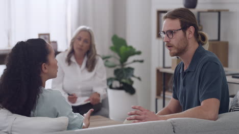 joven pareja interracial discutiendo durante la terapia