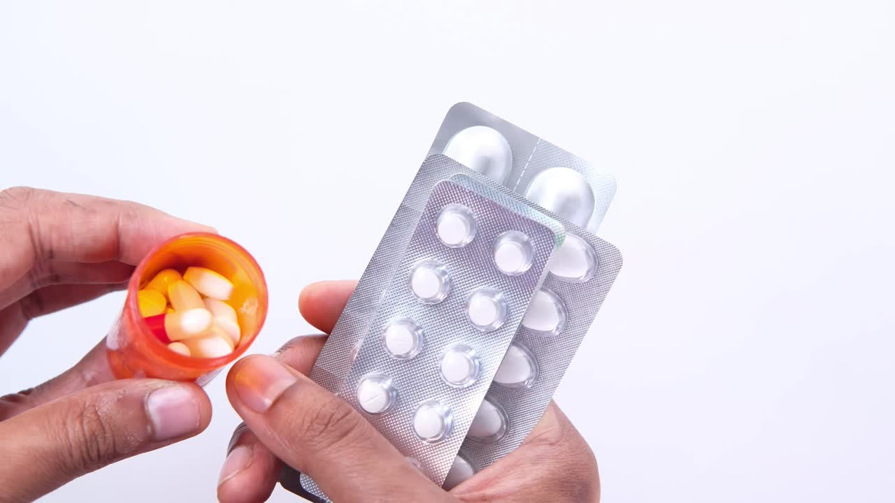 손은 여러 개의 약병 패키지와 약병 병을 들고 있습니다.