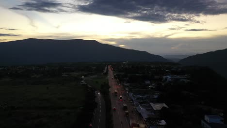 Puesta-De-Sol-Sobre-La-Ruta-Nacional-En-Colombia,-Se-Puede-Ver-Claramente-El-Paso-De-Los-Carros-Y-El-Trafico-De-La-Ruta