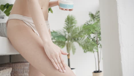 woman applying lotion to her leg