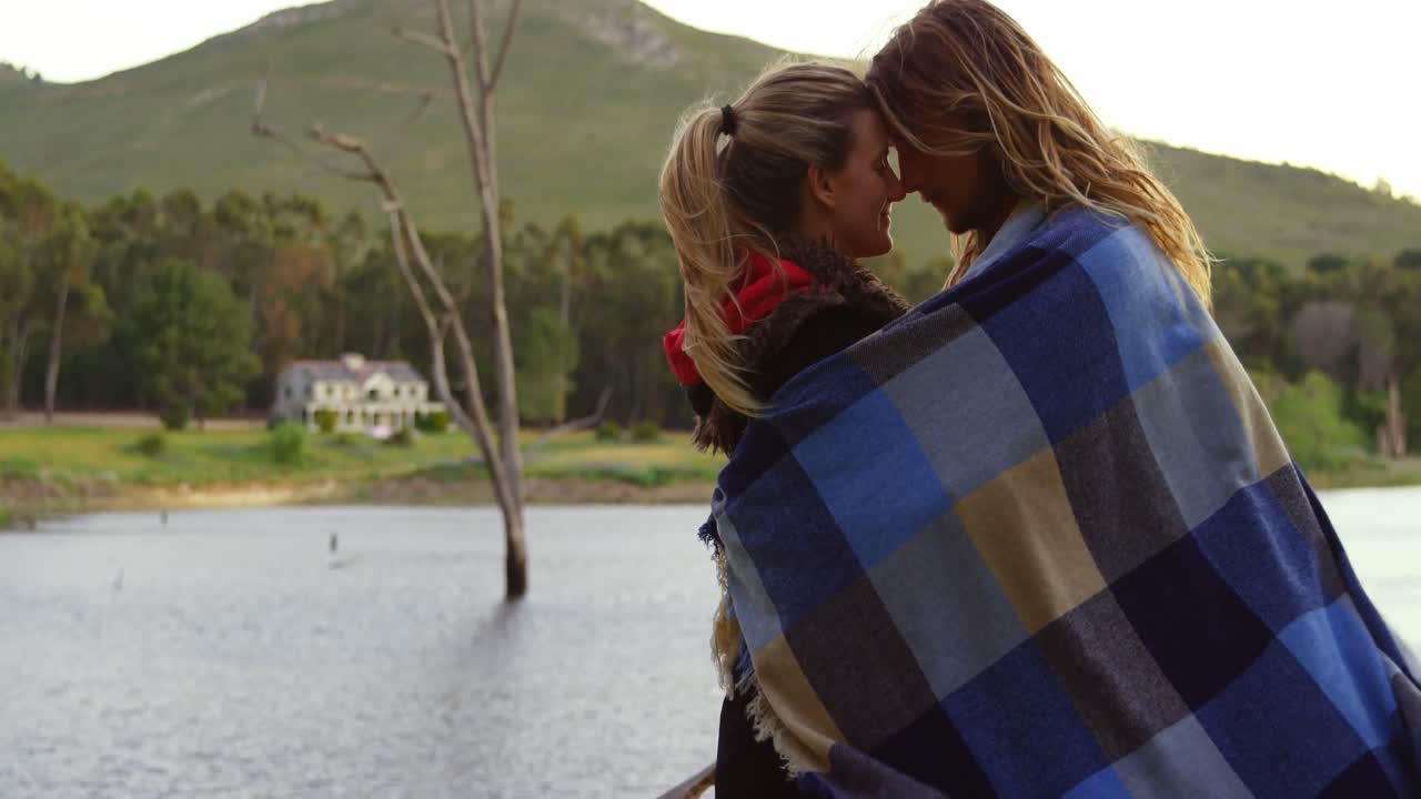 pareja romántica cabeza a cabeza cerca del lago 4k