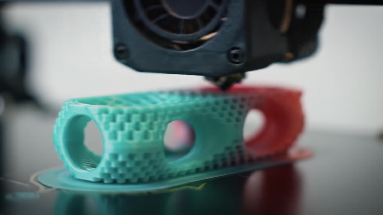 Workshop features a 3D printer at work creating a vibrant, custom-designed object. The printer uses various colors to layer a detailed item, showcasing modern technology.