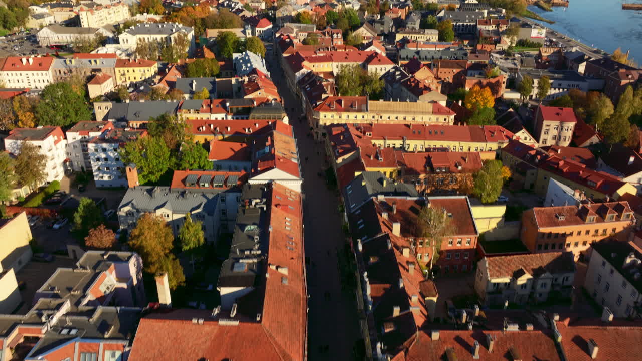 Drone footage above Kaunas Old Town streets located in Lithuania, Baltic states, Europe. Tilting up camera movement. Red rooftops are visible. High quality 4k prores footage.