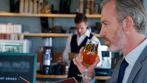 Geschäftsmann-Trinkt-Bier-Und-Schaut-Sich-Die-Speisekarte-An