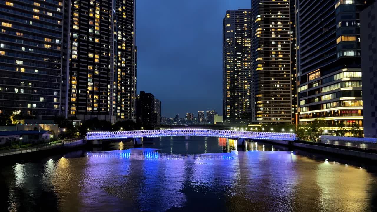 다채로운 불빛이 밤에 도시 다리를 비추고 평온한 강물에 반사됩니다.