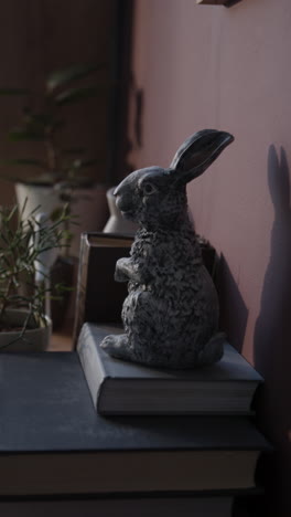 rabbit figurine decorated shelf with books and plants