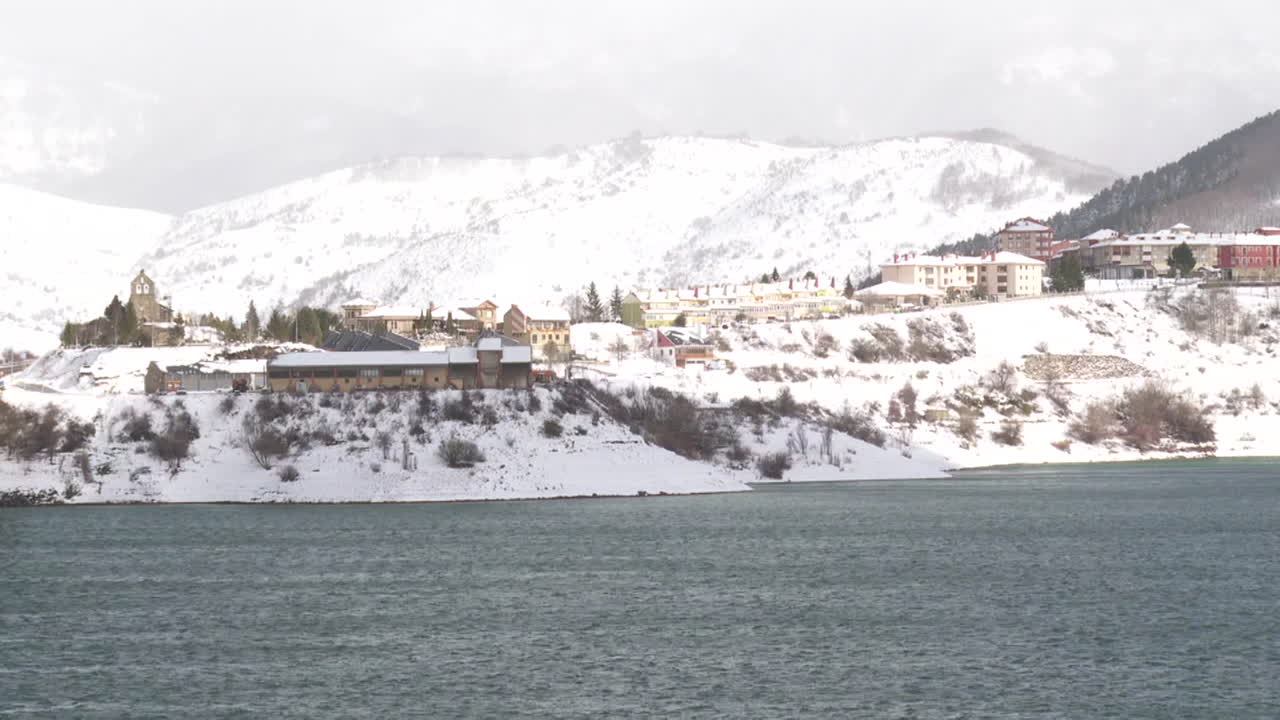 Snowy Village by a Lake in the Mountains
