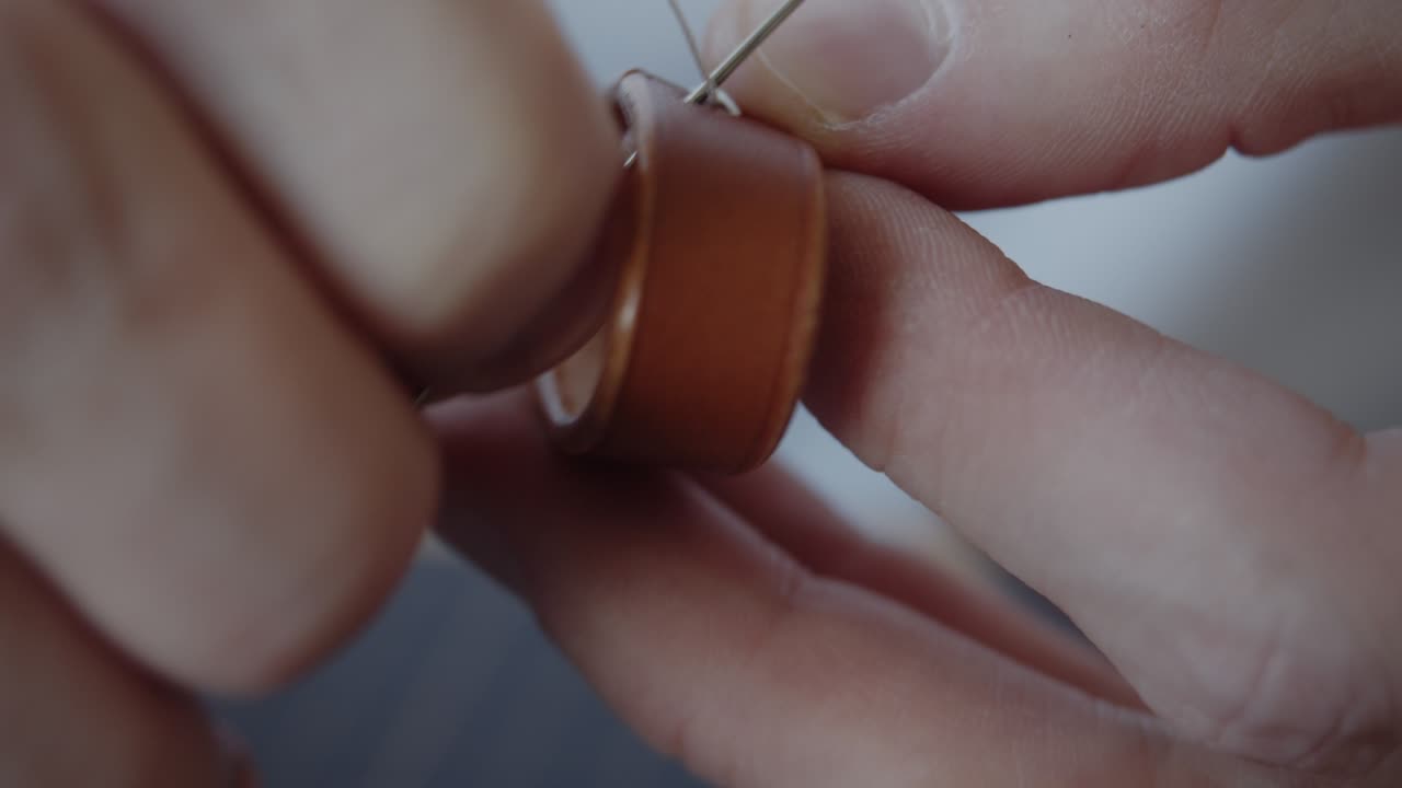 Hand stitching a leather loop for a belt close-up