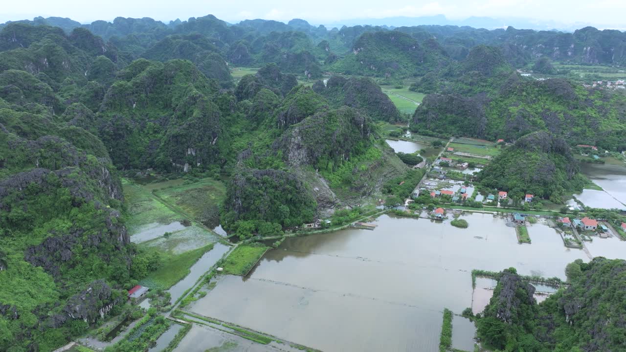 Lush mountains and flooded rice fields in Ninh Binh, Vietnam, viewed from above