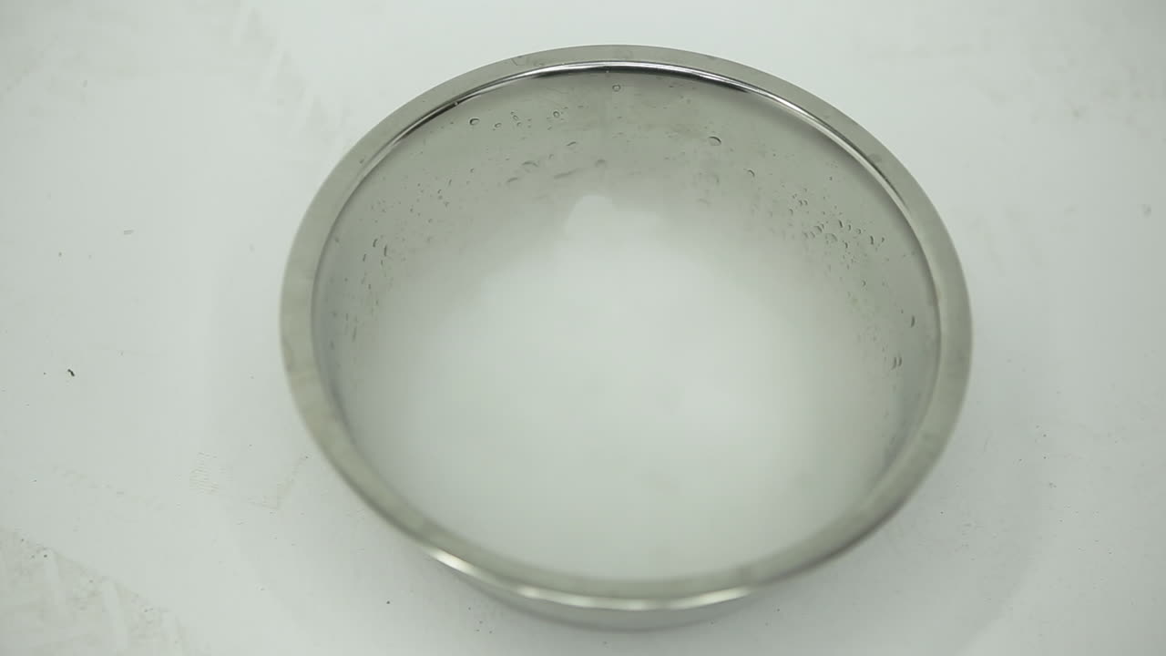 ボウルの中のドライアイスの煙を手で扇ぎ払う