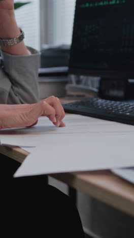 una mujer de negocios revisando documentos en su escritorio.