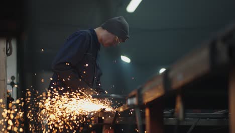 a man in protective glasses works with metal grinding polishing and stripping steel metal structures.