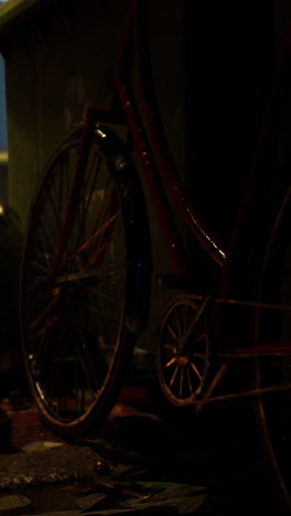 red vintage bicycle parked on a street at night