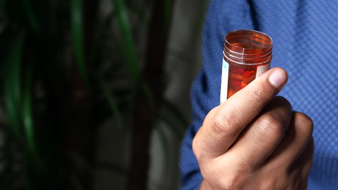 persona que sostiene un frasco de medicamento