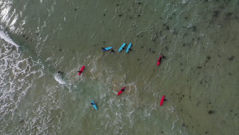 Antena-De-Ojo-De-Pájaro:-Niños-En-Clase-De-Surf-En-Aguas-Poco-Profundas-Olas-Pequeñas