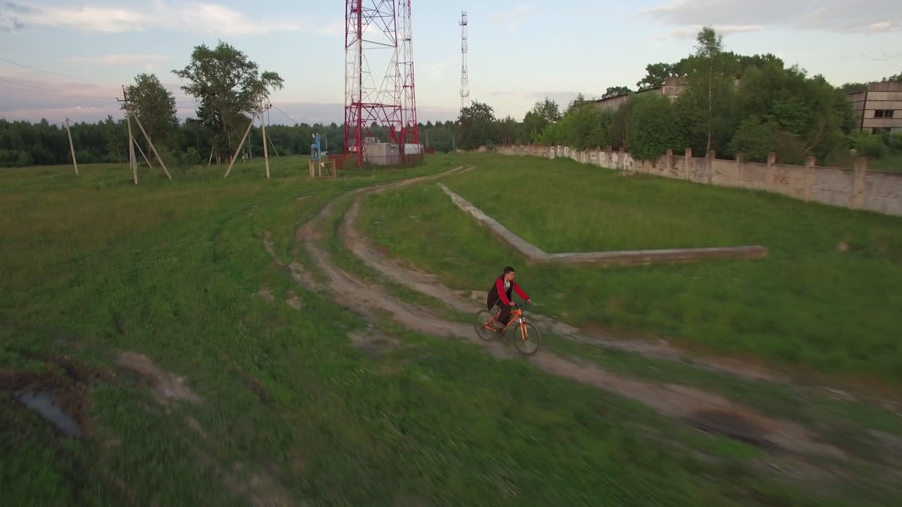 vista aérea de un niño montando una bicicleta en el campo