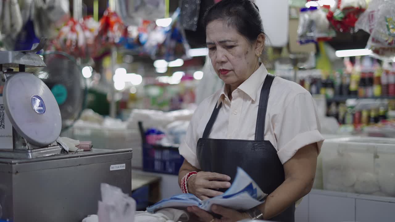 Elderly woman working at a market stall