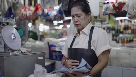 elderly woman working at a market stall