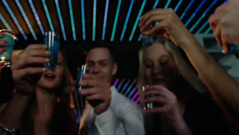 friends toasting tequila in bar