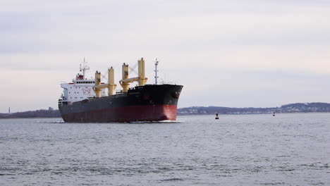 very large tanker making a turn across harbor, static tripod establishing