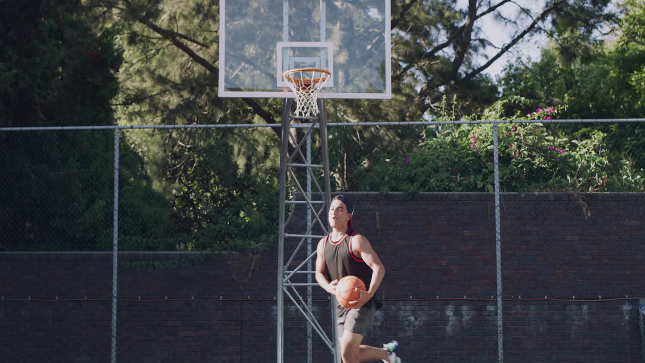 hombre disparando al baloncesto en la cancha al aire libre