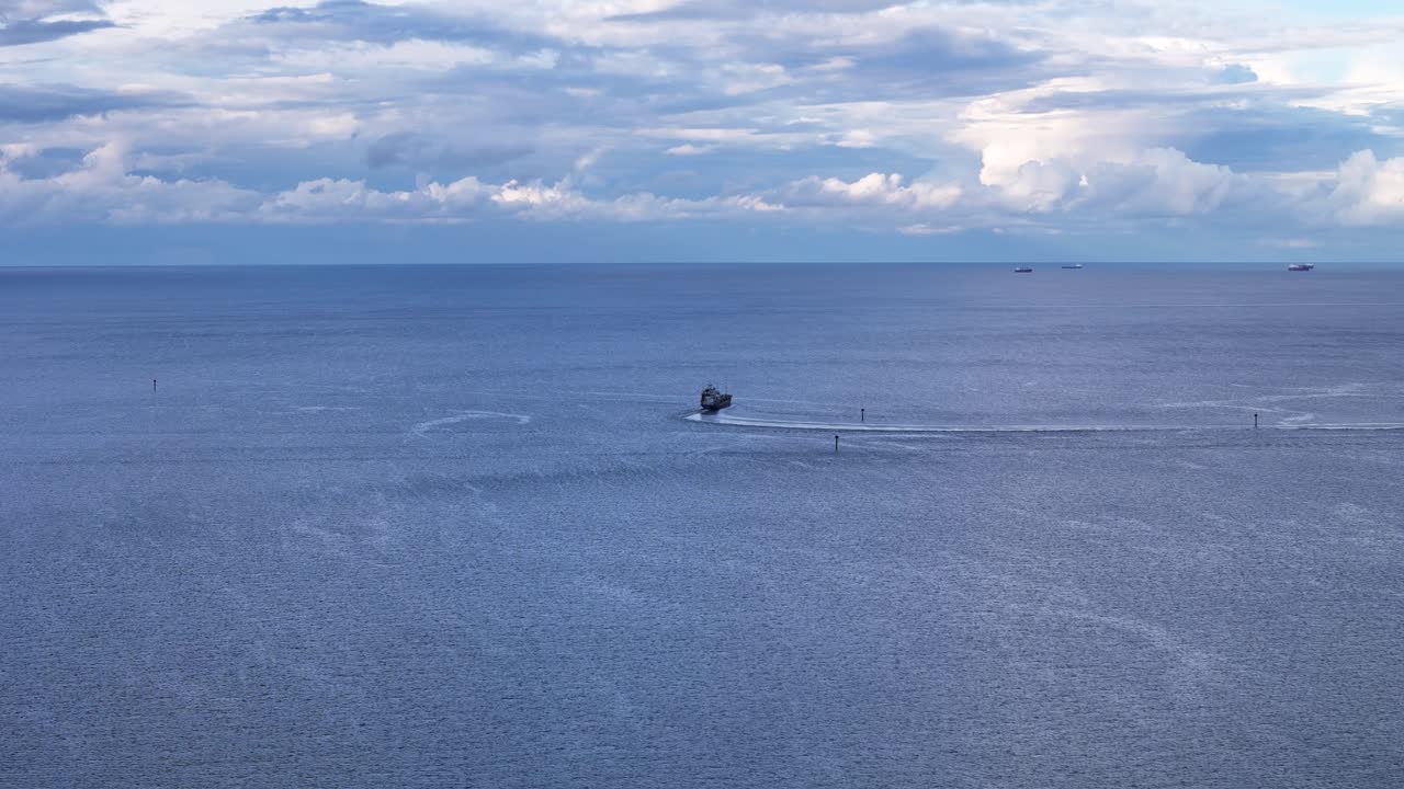 Cargo ships peacefully sail on the baltic sea near gdansk, poland, showcasing the beauty of the ocean and the importance of global trade slow motion aerial shot