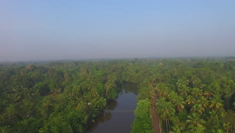 Toma-Aérea-Del-Río-Remanso-Y-La-Carretera-Del-Pueblo,-Bosque-De-Coco,-Cielo-Azul