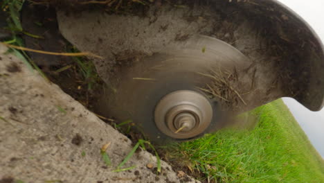 cuchillas de power edger en acción, recortando con precisión el césped a lo largo de la acera