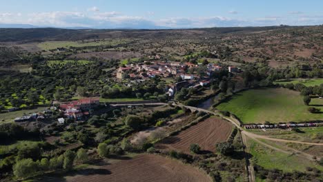 a drone flies over the village next to idanha-a-velha roman bridge establishing the valley in a beautiful aerial