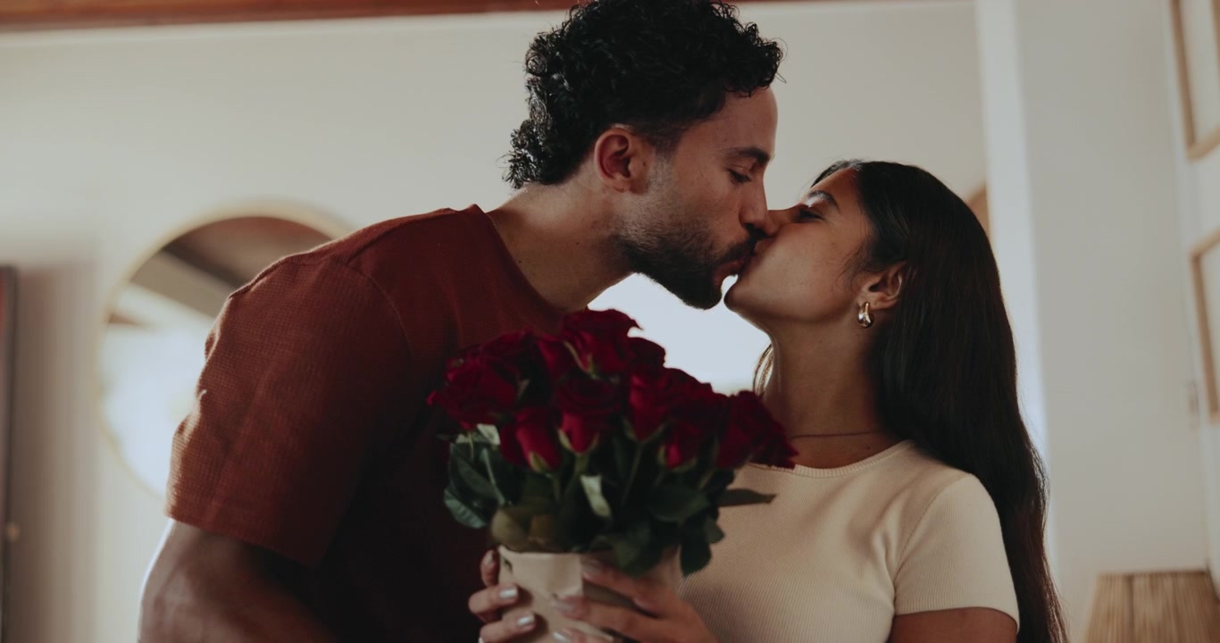 Man Surprising Woman with a Bouquet of Red Roses at Home