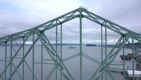 Cargo-ships-seen-in-distance-through-trusses-of-Astoria-Megler-Bridge-in-Astoria,-Oregon